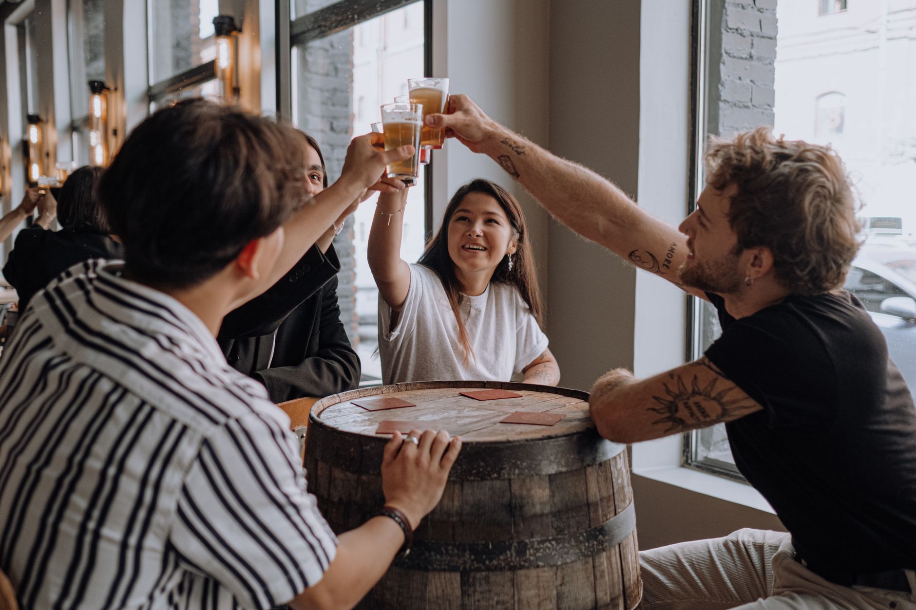 A group of friends raising glasses together at a bar table in Budapest