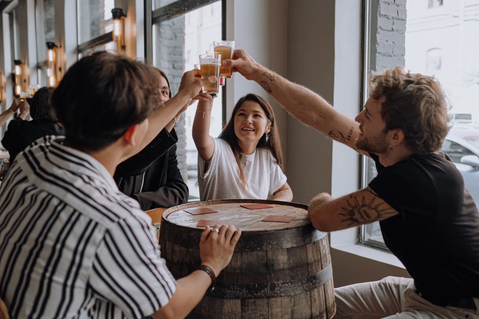 A group of friends raising glasses together at a bar table in Budapest